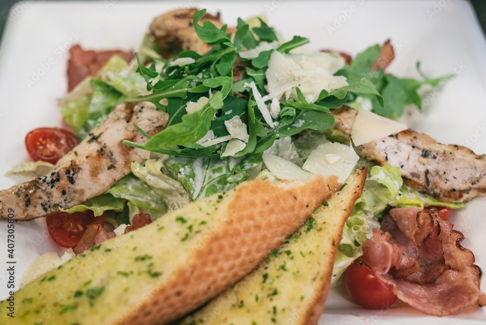 Caesar salad a green salad of romaine lettuce and croutons dressed with lemon juice olive oil, parmesan cheese and chicken. Also called Cesare salad Caesar salad a green salad of romaine lettuce and croutons dressed with lemon juice olive oil, parmesan cheese and chicken. Also called Cesare salad