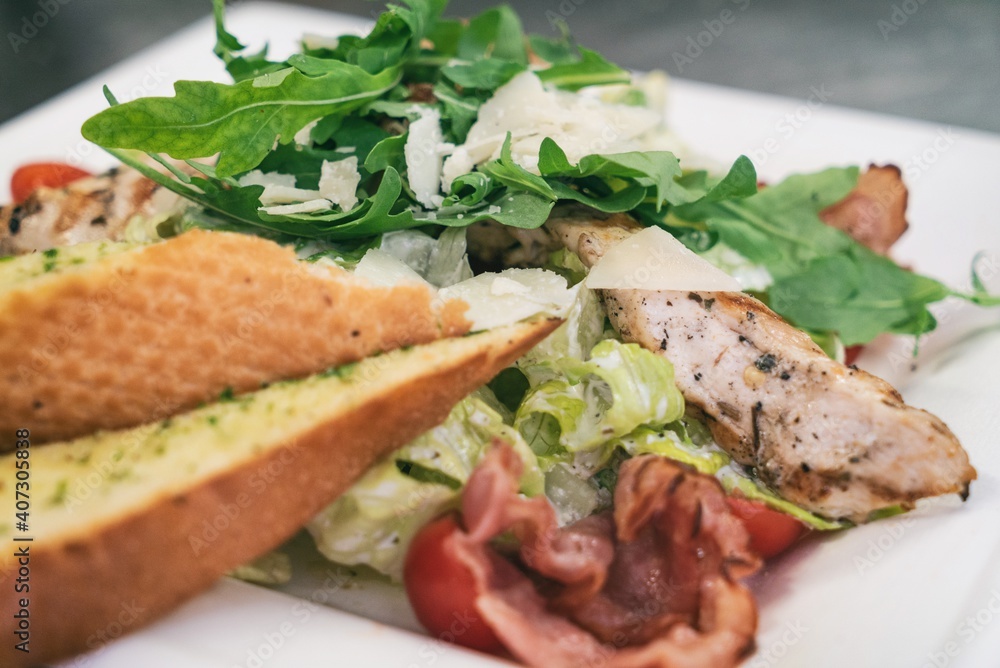 Caesar salad a green salad of romaine lettuce and croutons dressed with lemon juice olive oil, parmesan cheese and chicken. Also called Cesare salad Caesar salad a green salad of romaine lettuce and croutons dressed with lemon juice olive oil, parmesan cheese and chicken. Also called Cesare salad