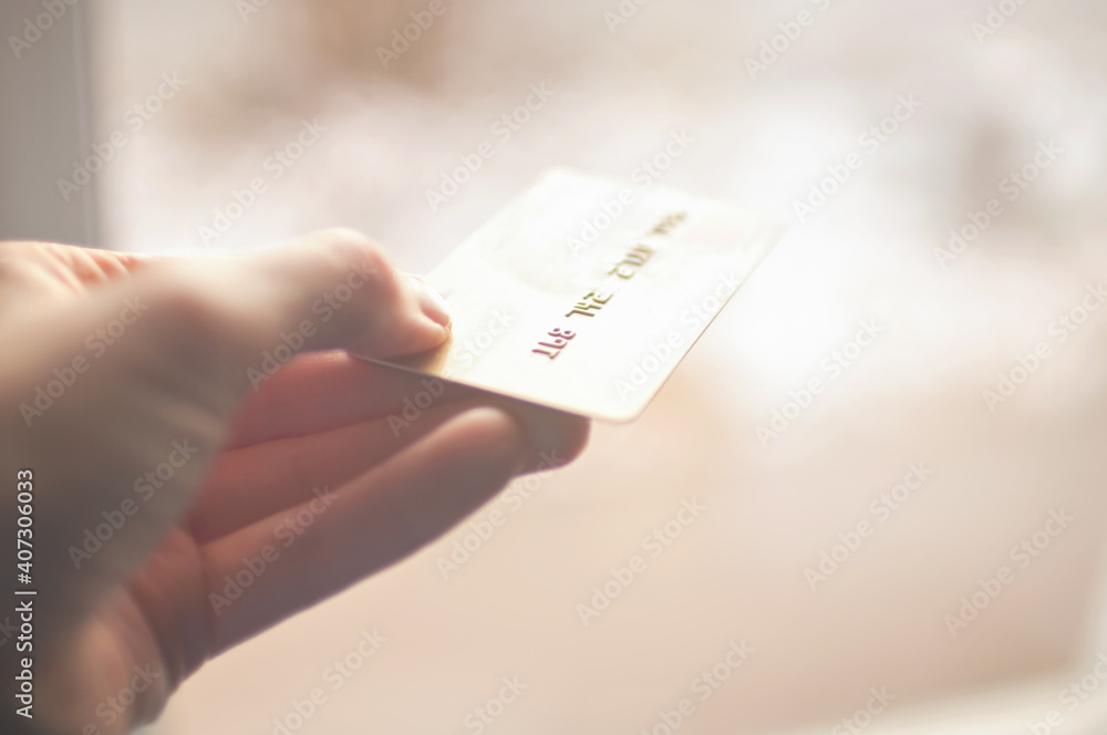 bank card of gold color in hands on a background of sunlight bank card of gold color in hands on a background of sunlight