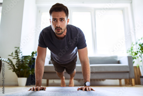 Fototapeta Naklejka Na Ścianę i Meble -  Man doing pushup exercise during home workout.