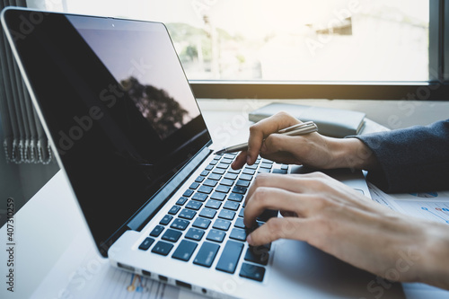Business woman hands using laptop analysis the graph for Setting challenging business goals and ready to achieve the target.