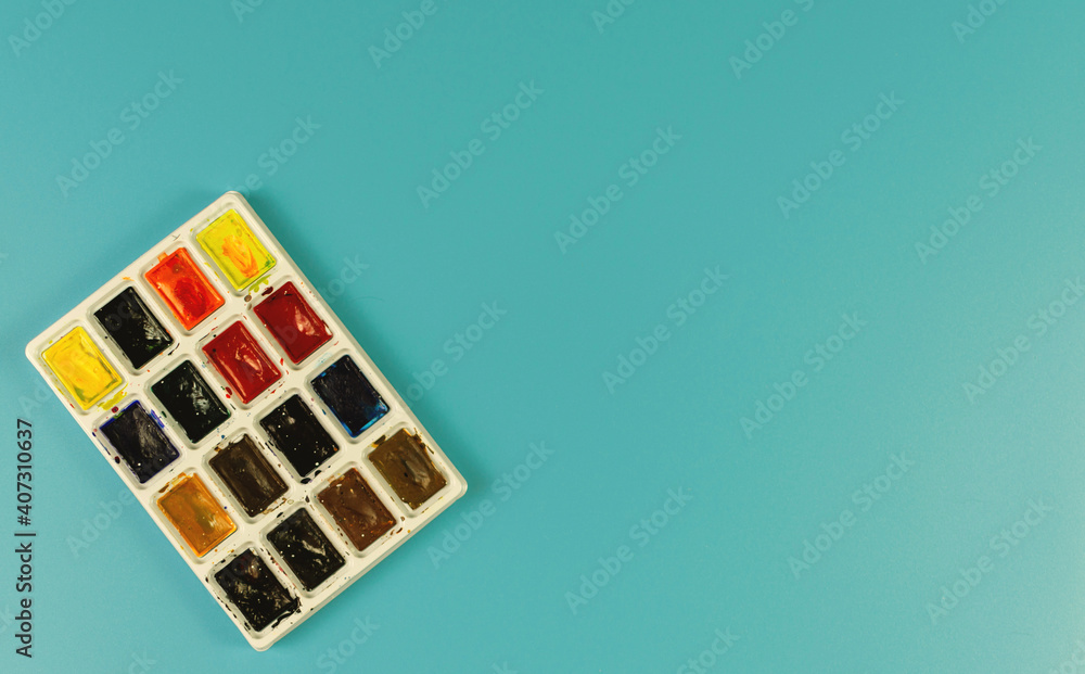 Paints and brushes on a turquoise background Paints and brushes on a turquoise background