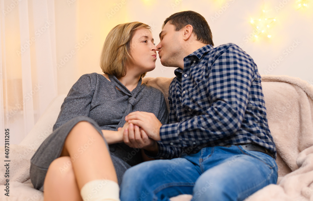 portrait of adult couple sitting on a sofa at home