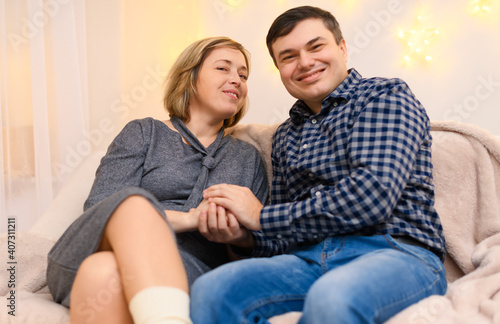 portrait of adult couple sitting on a sofa at home