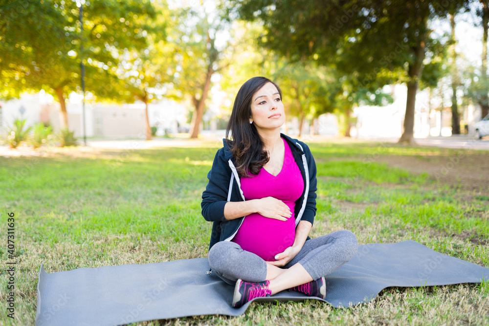 Pregnant woman resting on a yoga mat after her workout Pregnant woman resting on a yoga mat after her workout