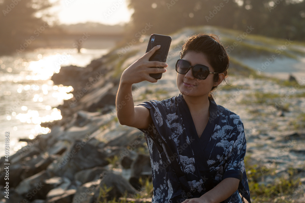 young woman enjoying on the river bank with the sea in the background young woman enjoying on the river bank with the sea in the background