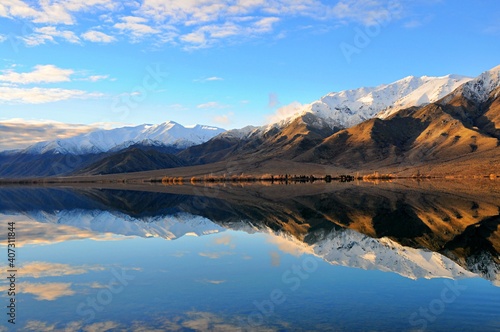 Landscape of snowcapped mountain reflected in calm water of lake