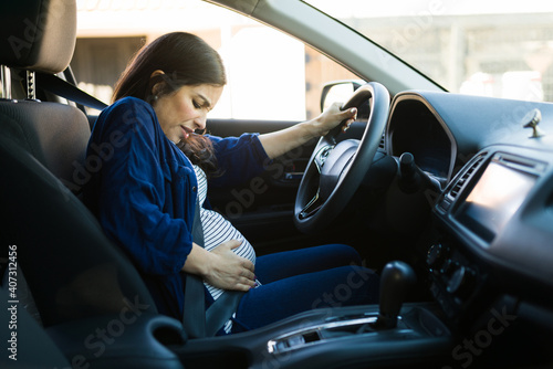 Pregntant woman with cramps while driving her car
