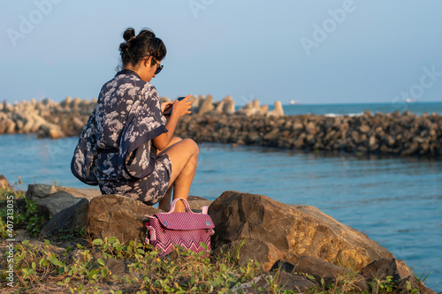 young woman enjoying on the river bank with the sea in the background