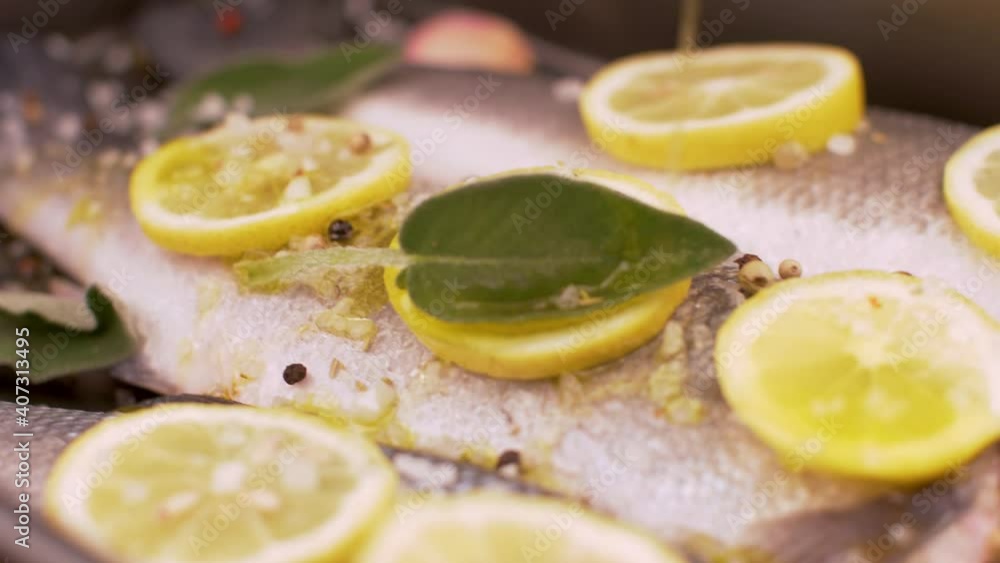 fresh sea bass pready for cooking in the pan with lemon slices and sage fresh sea bass pready for cooking in the pan with lemon slices and sage