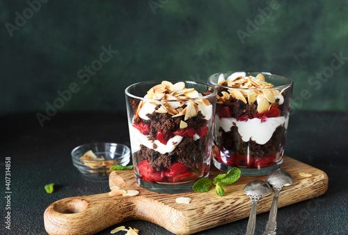 Quadro su tela Dessert black forest with cherries in a glass on a wooden board