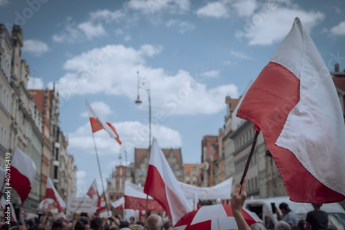 The Polish flag waving over the crowd of people 