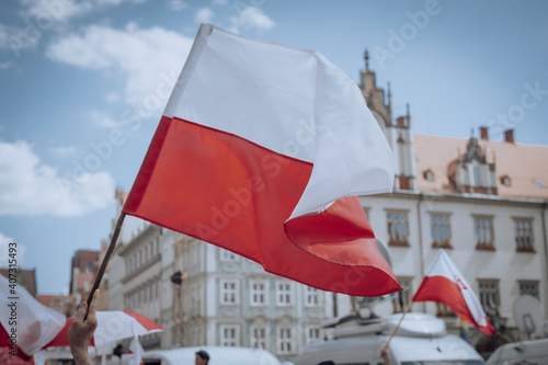 The Polish flag waving over the crowd of people 