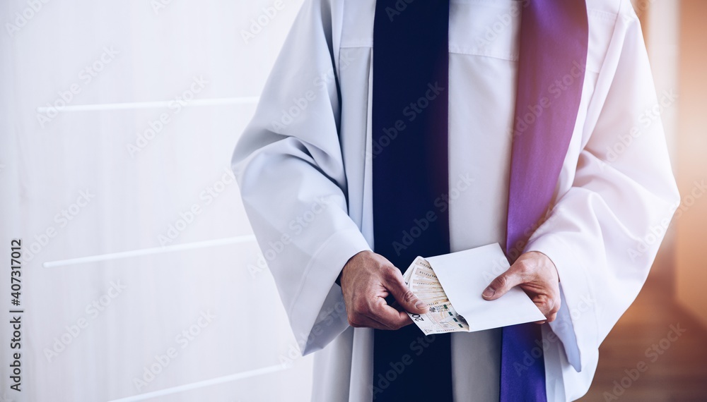 Catholic priest holding envelope with money during pastoral visit called kolenda in Poland, church and money
