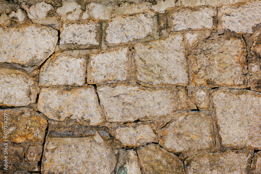 Fototapeta premium Natural old beige stone wall textured background. Close up. Copy space.