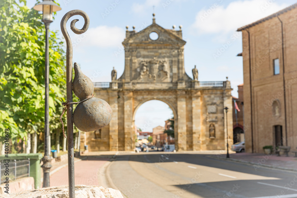 Fototapeta premium a calabash on a walking stick (symbol of the way to Santiago) in front of the arch of San Benito in Sahagun, province of Leon, Castile and Leon, Spain