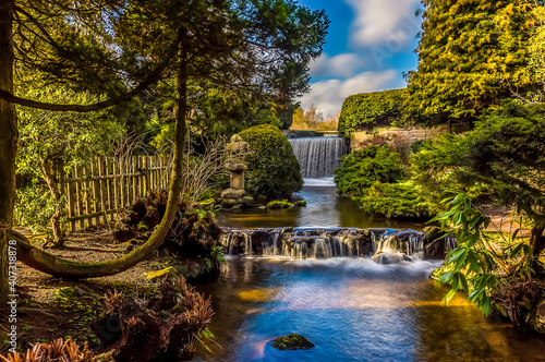 A long exposure view of a waterfall and weir at Newstead Park, Nottinghamshire, UK photo