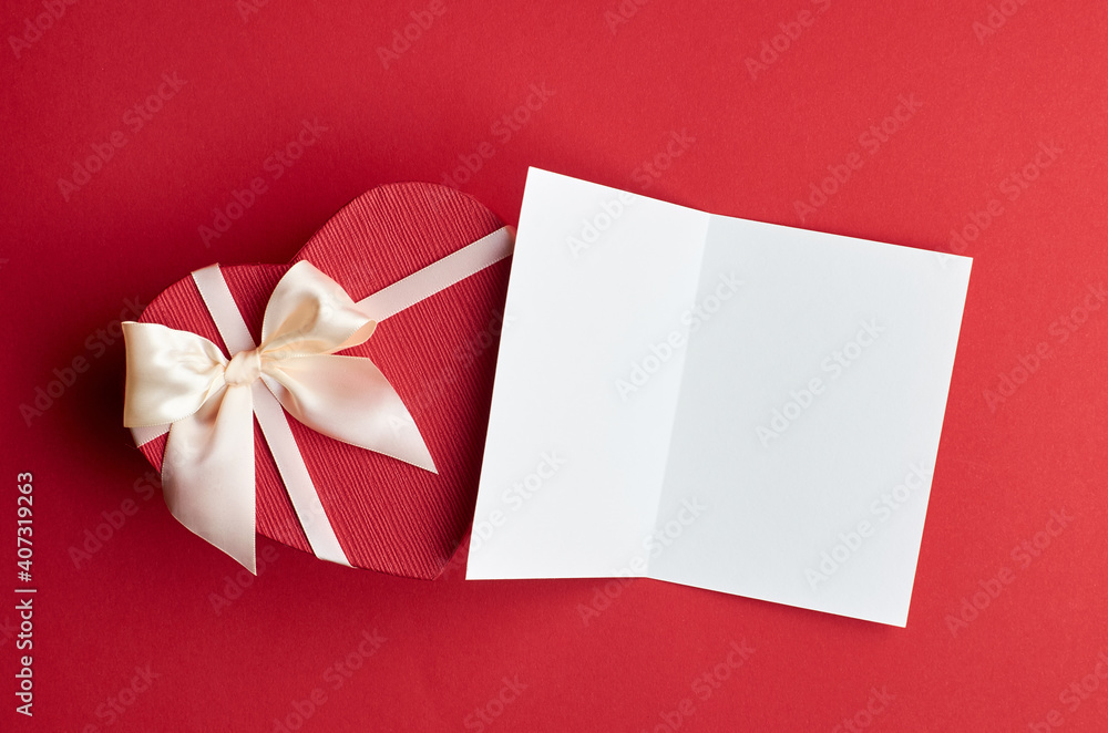 Valentines day card mockup with heart gift box on red paper background Valentines day card mockup with heart gift box on red paper background