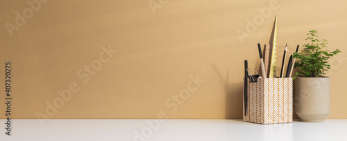 Office desk with space for poster, blank picture frame or text, desk objects, office supplies and bright beige background.	