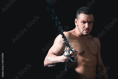 Perfect male body. Man hold a chain. Isolated on black. Copy Space.