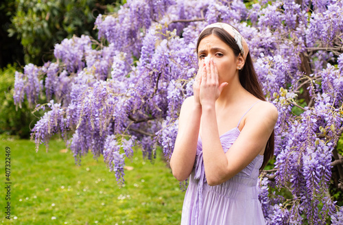 Spring allergy. Girl with nose sneezing. Allergic symptom concept. Woman being allergic to blossom outside.