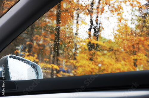 raindrops on the car window, autumn view from the car when driving.