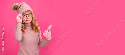 attractive adult woman with mobile phone isolated wearing warm clothes