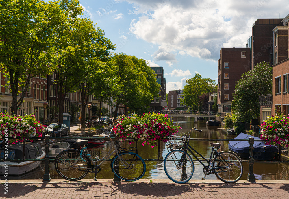 bicycles on a bridge in amsterdam with bunch of flowers on a canal