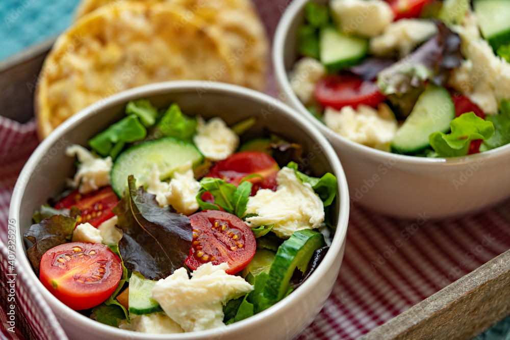vegetable salad with cheese in a white bowl on wooden background.top view food. vegetable salad with cheese in a white bowl on wooden background.top view food.