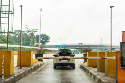 A car exits the toll gate on one of Indonesia's toll roads, with the crossbar closed photo