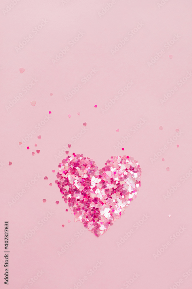 Valentine's Day background February 14th. Heart made of pink hearts confetti on pink background. Valentines day creative concept. Flat lay, top view, copy space