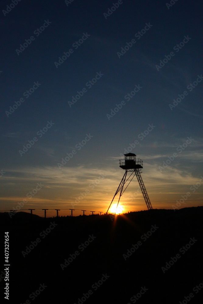 Historical watchtower as a remain of Cold war Iron curtain during the sunset in Čížov, Czechia