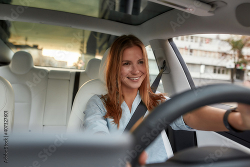 Obraz na plátně Portrait of smiling young woman driving modern car