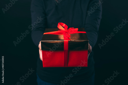 Fototapeta Naklejka Na Ścianę i Meble -  Close up photo of female hands holding red gift box.