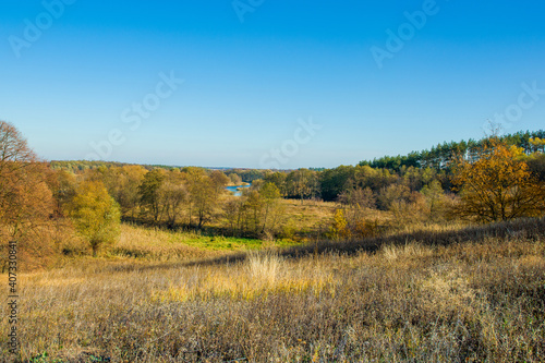 Beautiful autumn landscape with blue river and forest