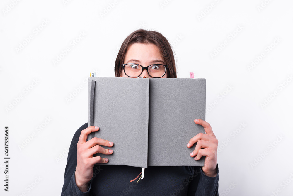 Photo of girl looking surprised and cover face with planner or agenda, time management. Photo of girl looking surprised and cover face with planner or agenda, time management.