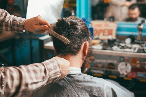Photo of barber preparing man for haircut.