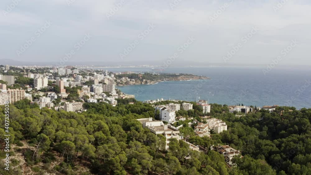 City in the mountains on the Mediterranean dron 4K video. Aerial view houses and streets stand on mountain peaks with pine trees against which the waves of the sea crash. City in the mountains on the Mediterranean dron 4K video. Aerial view houses and streets stand on mountain peaks with pine trees against which the waves of the sea crash.
