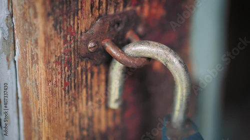 Detail macro shot of an old rusty lock. Closeup of an unlocked antique metal padlock on wooden door frame in 4k.