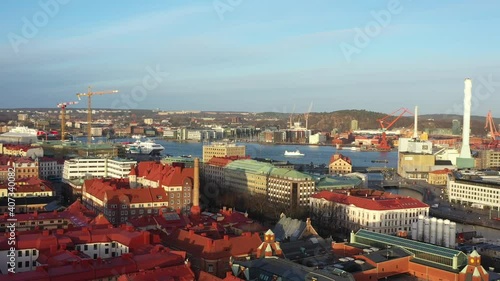 4K Aerial footage over Gothenburg city, Sweden. Drone flying over rooftops capturing the harbor. Sunset in December. photo