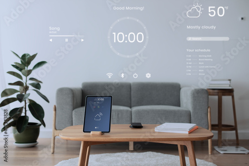 Digital tablet screen with smart home controller on a wooden table photo
