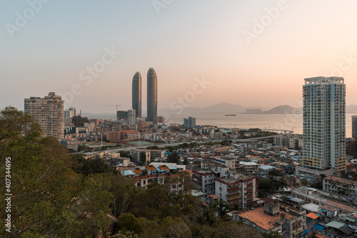 Xiamen city skyline with modern buildings, old town and sea at dusk