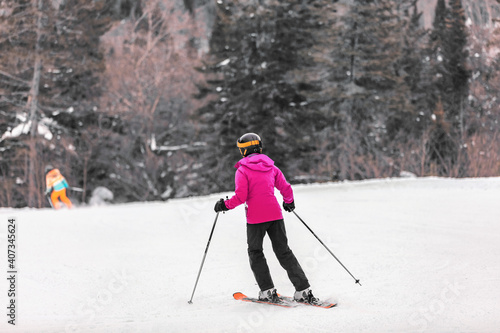 Downhill skiing Alpine ski. Woman skier riding white powder snow slope in cold weather. winter sports.