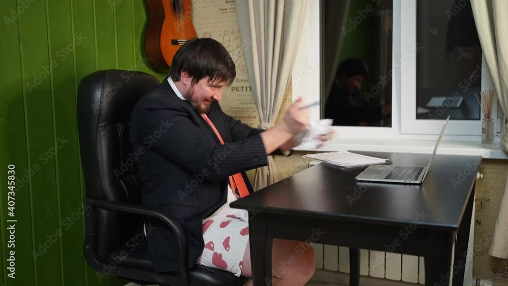 man in shorts, a jacket and a tie rips paper with graphs on a conference online man in shorts, a jacket and a tie rips paper with graphs on a conference online