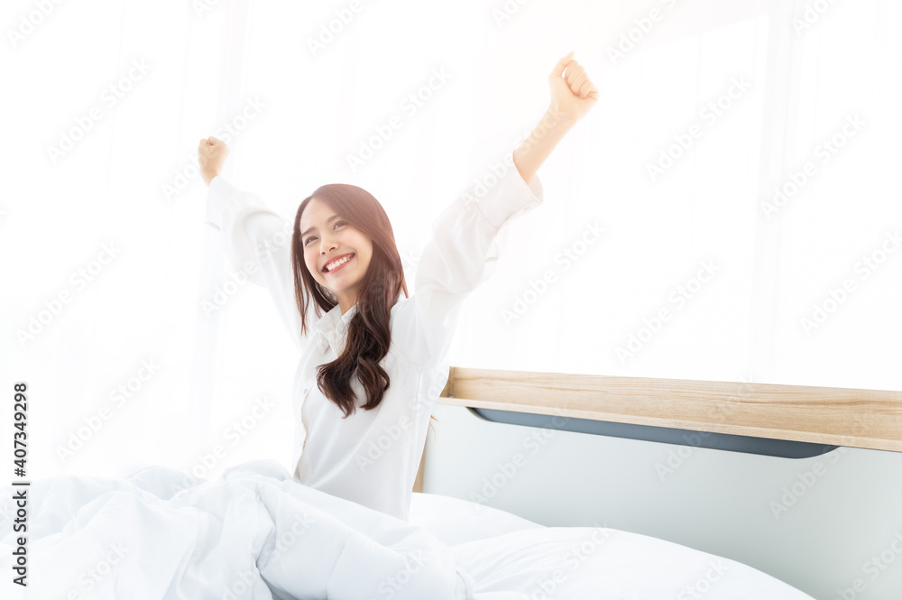 Beautiful women asian wake up in morning in bedroom. She clothing white dress stretching body and feeling fresh Beautiful women asian wake up in morning in bedroom. She clothing white dress stretching body and feeling fresh