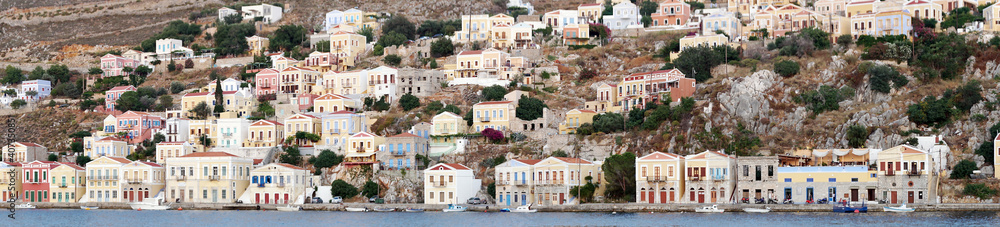 A picturesque view from the sea to the Greek island village SYMI. Panoramic seafront houses in multi colors and authentic neoclassic architecture.                    