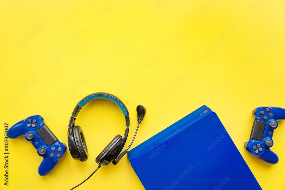 Top view of blue gaming controllers, console and headphones. Virtual regality gaming accessories.
