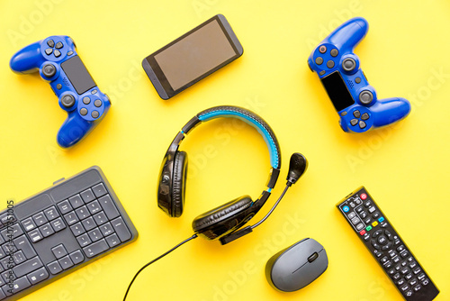 Obraz na płótnie Modern toys - gaming controller, headphones, tv remote control, smart phone and computer keypad and mouse. Virtual regality gaming accessories. w salonie