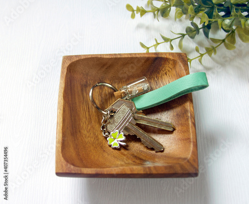 Keys attached to leather keychain on wood plate