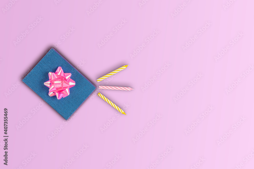 Gift box with bow surprise birthday with candles for cake on pink background copy space